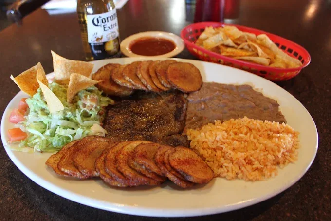 Mexican Steak plate: top sirloin with seasoned potatoes, guacamole salad, refried beans, Mexican rice, and warm tortilla chips with salsa