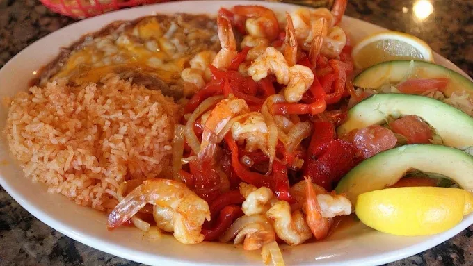Shrimp fajitas with red peppers and onions, Mexican rice, refried beans and sliced avocado